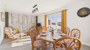 A dining area with a round table, chairs, and a clock on the wall. - Holiday home for 6 in Saint Hilaire de Riez (Saint-Hilaire-de-Riez)