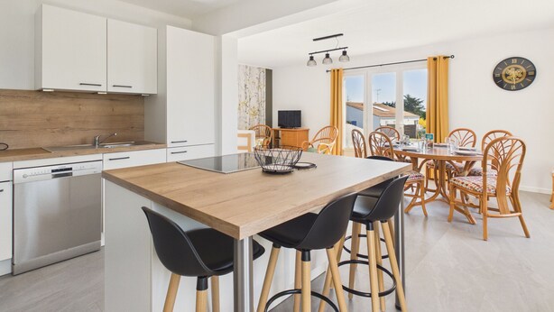 A modern kitchen with white cabinets, a wooden island, and black chairs. - Holiday home for 6 in Saint Hilaire de Riez (Saint-Hilaire-de-Riez)