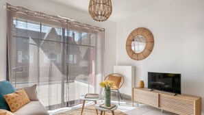 Una sala de estar moderna con sofá, televisor y objetos decorativos.