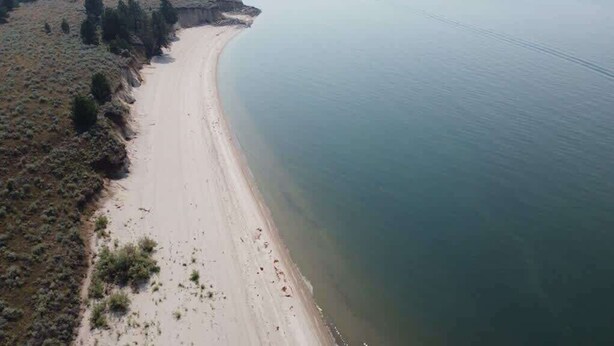 An aerial view of a beach with a sandy shoreline and sparse vegetation. - Cascade Cabin Mountain Getaway with Private Beach (Cascade)