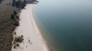 An aerial view of a beach with a sandy shoreline and sparse vegetation. - Cascade Cabin • Lake Access • Boat & Trails (Cascade)