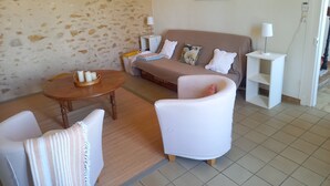 Een woonkamer met een bank, fauteuils, een salontafel en een wereldkaart aan de muur.