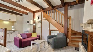 A cozy living room with a wooden staircase, a sofa, a chair, and a small table. - Les Saules Blancs - Plouharnel (PLOUHARNEL)