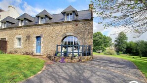 A stone building with a large arched window and a blue door. - Pont Bihan - CARNAC - Gîte (CARNAC)