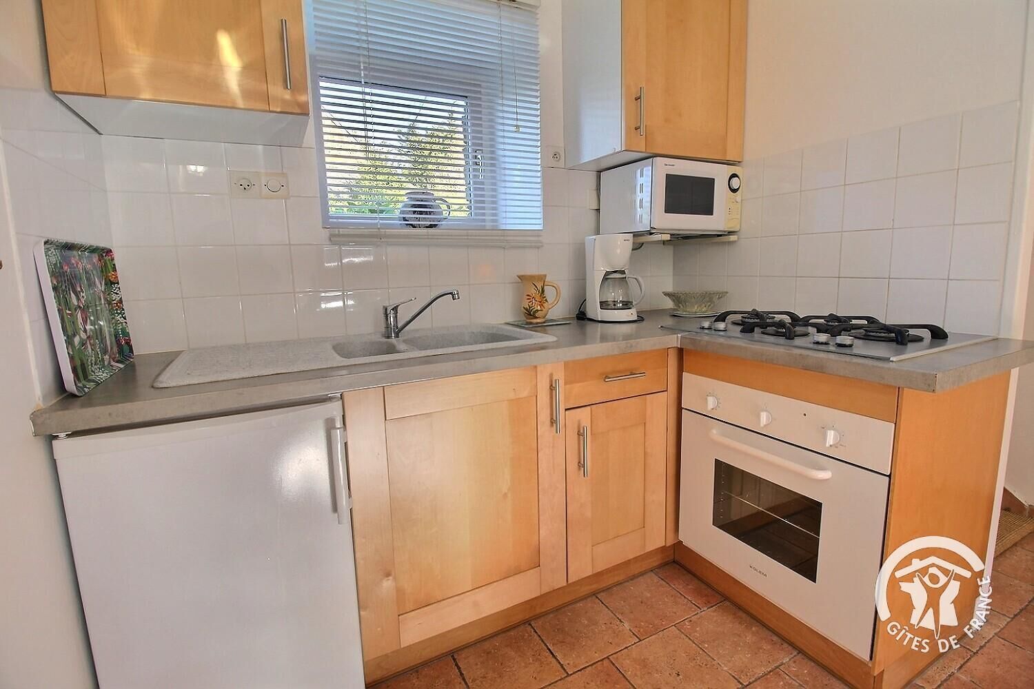 A kitchen with a sink, stove, microwave, and oven.