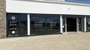 Ein Schaufenster mit großen Glasfenstern, das verschiedene Spezialitäten wie Pâtisseries und Gebäck präsentiert.