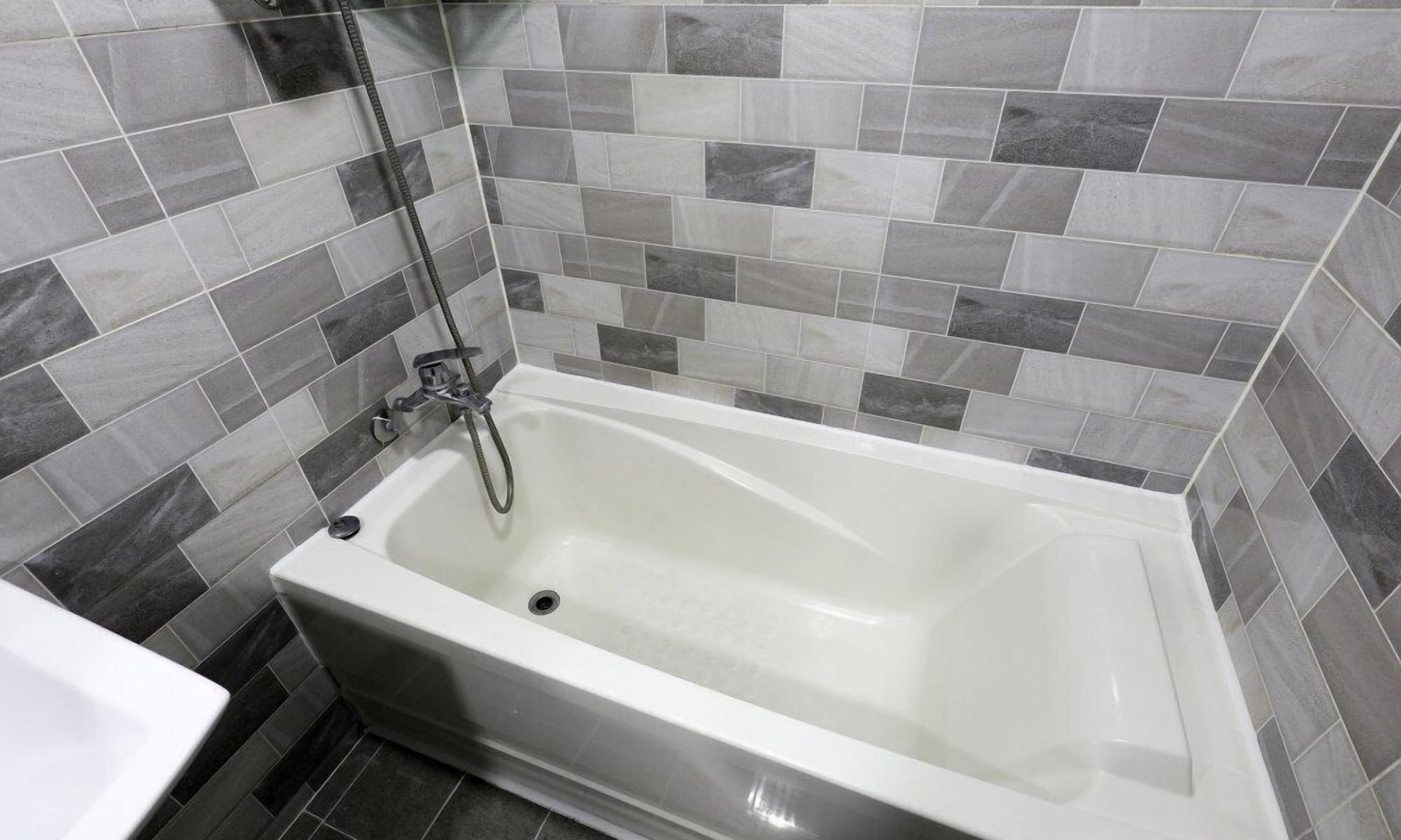 Une salle de bain avec une baignoire, une douche et un lavabo.