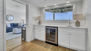Une cuisine moderne avec des meubles blancs, un lave-vaisselle encastré et une fenêtre au-dessus de l’évier.
