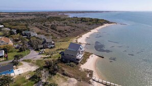 An aerial view of a coastal property with a beach, houses, and a pier. - Shore Enuf - Ocracoke Island (Ocracoke)