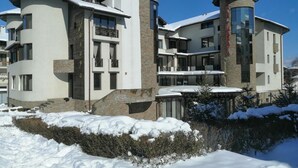 Un hotel de varios pisos con un diseño arquitectónico moderno, que cuenta con balcones y una entrada destacada.