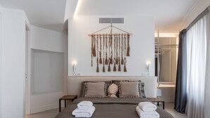 Un dormitorio moderno con una cama, mesitas de noche, una lámpara de pared y un adorno colgante de macramé.