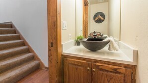 A bathroom with a large mirror, a stone sink, and a wooden cabinet. - Near Hot Springs + Downtown Ouray | Deck with Views (Ouray)