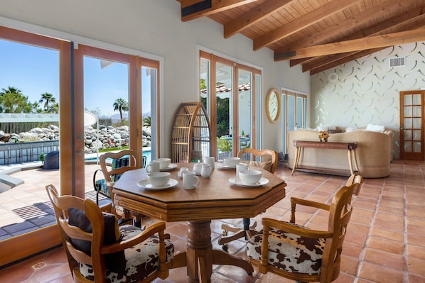 Un espace repas avec une table ronde, des chaises et une vue sur l’extérieur.
