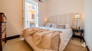 A bedroom with a bed, bedside table, and a mirror.