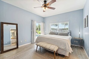 A bedroom with a bed, a ceiling fan, a window, a mirror, and a bench. - Poolside Bliss and a Family-Friendly Oasis (Naples)