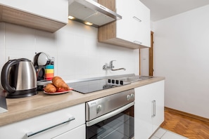 A modern kitchen with a stainless steel kettle, a toaster, a plate with croissants, a built-in oven, and a sink. - Sorgenfrei 2-bedroom apartment in Rovinj Old Town (Rovinj)