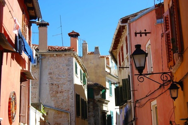 A narrow street with buildings featuring traditional architecture, including stone walls and tiled roofs. - Sorgenfrei 2-bedroom apartment in Rovinj Old Town (Rovinj)