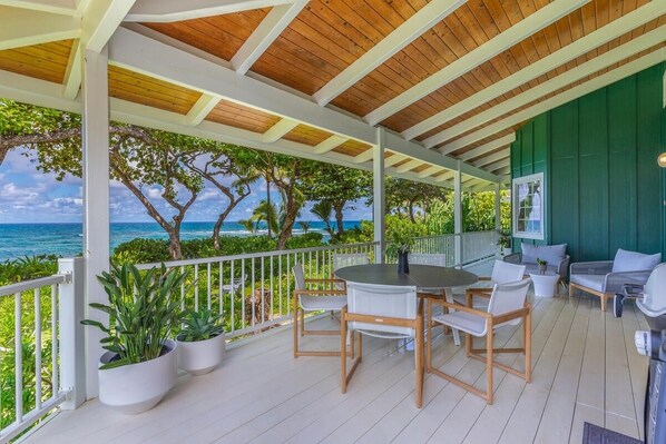 A covered outdoor area with a wooden ceiling, white railings, and a view of the ocean. - Camp Alealea 2 3 Bedroom Home by RedAwning (Hanalei)