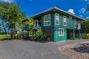 A green two-story house with a porch and a small staircase. - Camp Alealea 2 3 Bedroom Home by RedAwning (Hanalei)
