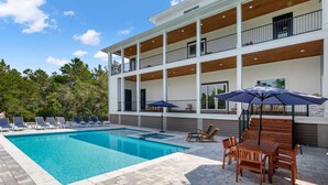 Un bâtiment à deux étages doté d’une piscine, d’un espace extérieur aménagé et d’un patio couvert.