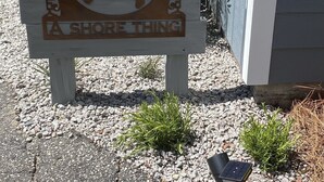 A wooden sign with a crab design and the text "A Shore Thing" in a coastal setting. - Great location! Fully fenced in yard and expansive deck. Come and relax! (Oak Island)