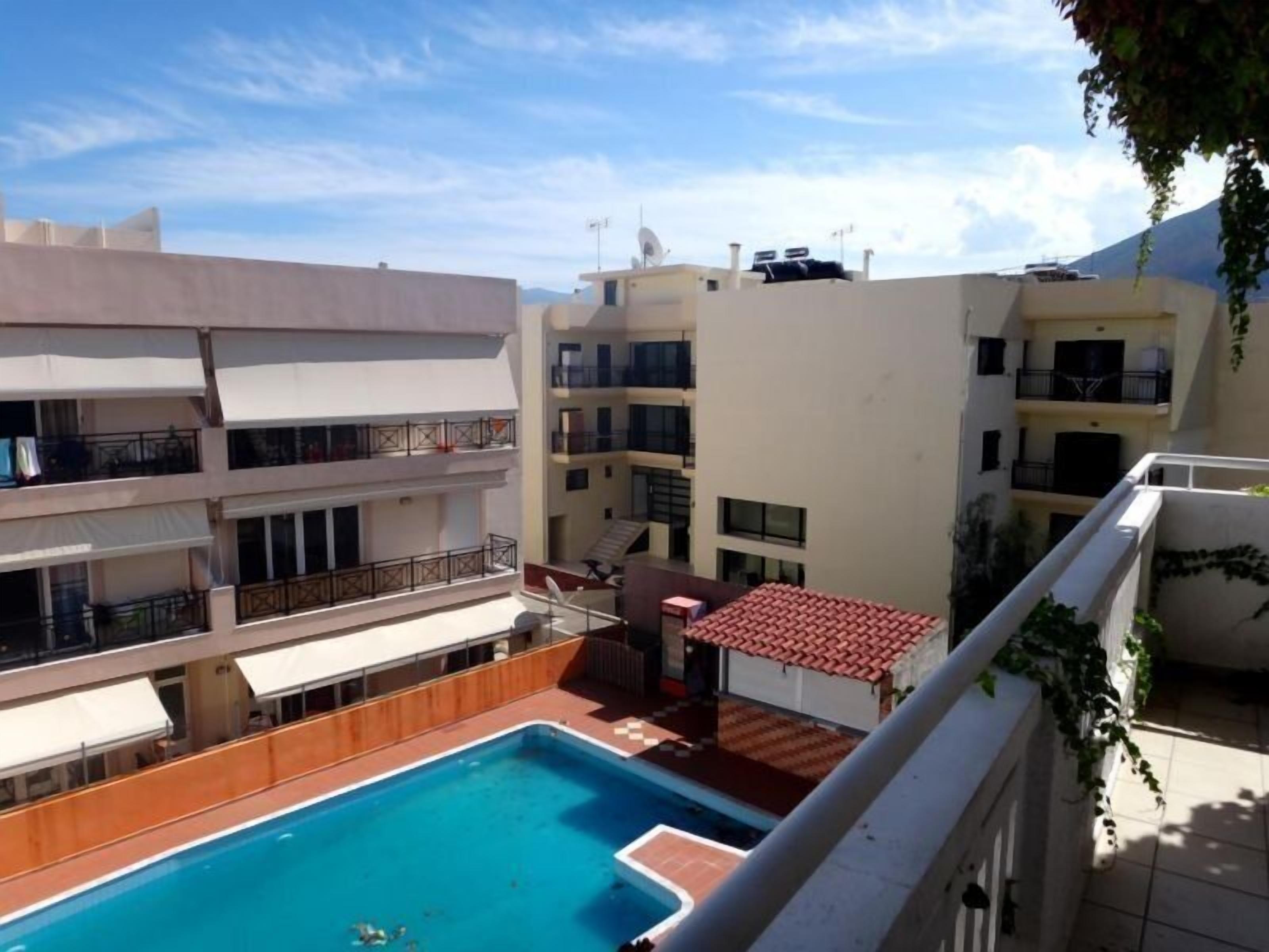 A rooftop swimming pool with a view of adjacent buildings.