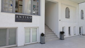 A building with a sign reading "ANTIKO Apts & Studios" and a staircase leading to an upper level. - Maria Apartments (Hersonissos)