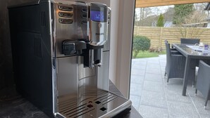 A coffee machine with multiple brewing options, a digital display, and a water reservoir.