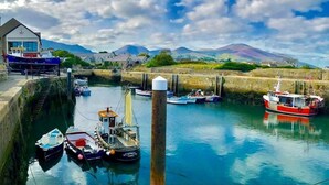 A harbor with boats docked, a lighthouse, and a mountainous backdrop. - Foot of the Mournes - Cottage - Sleeps 4 - Parking (Newry)