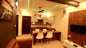Una cocina moderna con comedor, televisor y sofá.
