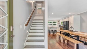 A modern kitchen with wooden flooring, a built-in bench, and a staircase leading to another level. - Helen, Georgia ★ Yonah Mtn, Hot Tub, Games + Grill (Helen)