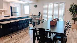 A modern kitchen with a central island, dining area with chairs, and a potted plant. - Beautiful, privately owned, Family Friendly, 3BR, Heated Pool, A+ Location! (Scottsdale)