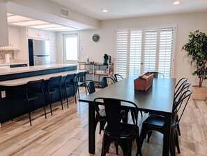 A modern kitchen with a central island, dining area with chairs, and a potted plant. - Beautiful, privately owned, Family Friendly, 3BR, Heated Pool, A+ Location! (Scottsdale)