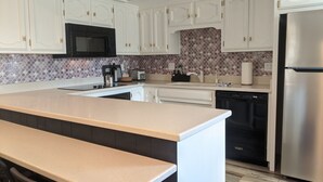 A modern kitchen with white cabinets, a stainless steel refrigerator, a microwave, and a dishwasher. - Beautiful, privately owned, Family Friendly, 3BR, Heated Pool, A+ Location! (Scottsdale)