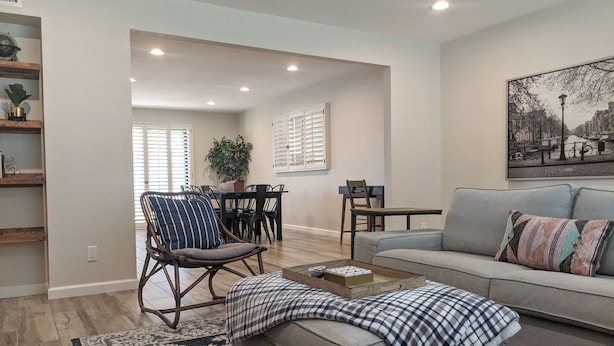 A spacious living room with a sofa, a coffee table, and a dining area with a table and chairs. - Beautiful, privately owned, Family Friendly, 3BR, Heated Pool, A+ Location! (Scottsdale)