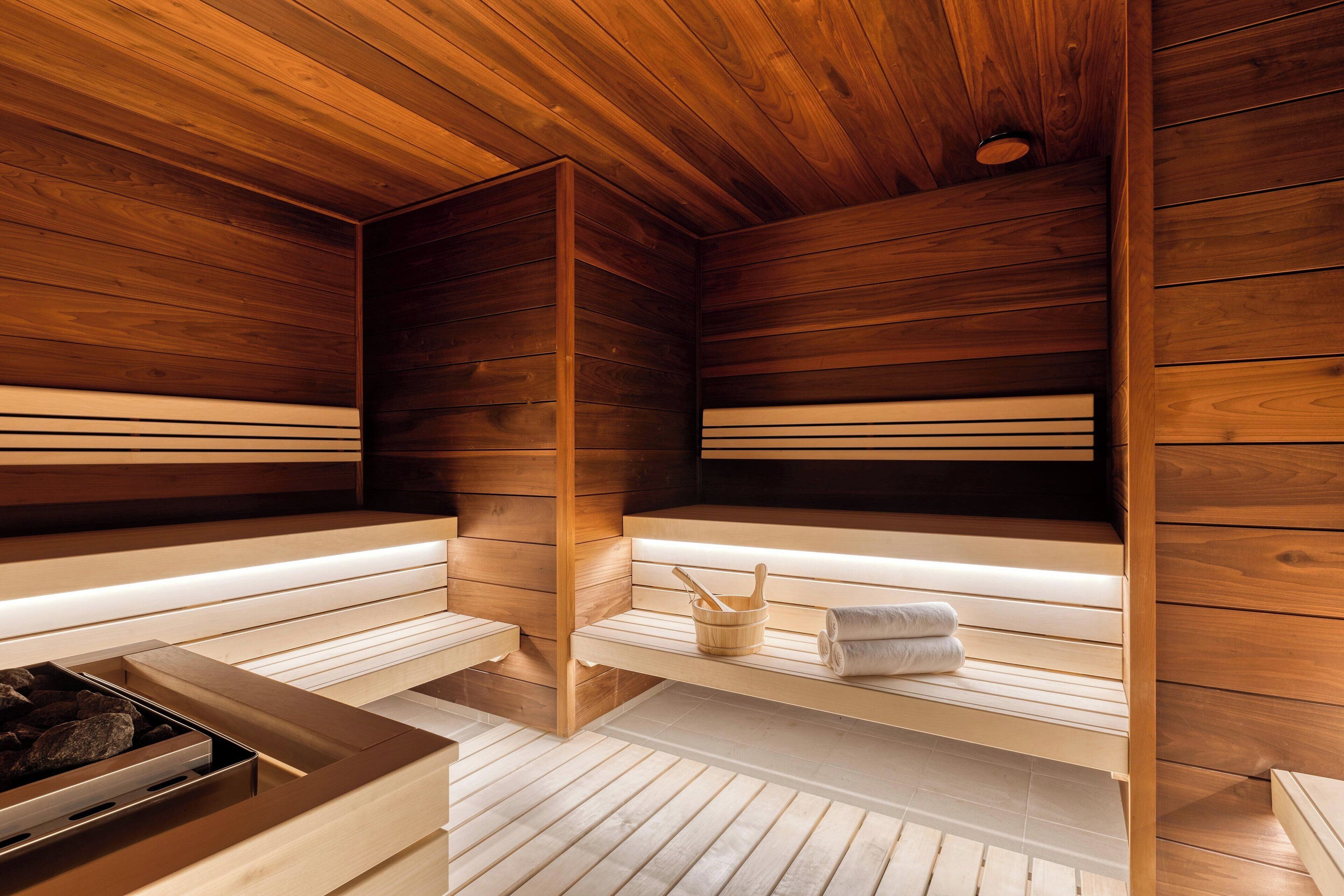 A sauna with wooden benches and a stone basin.