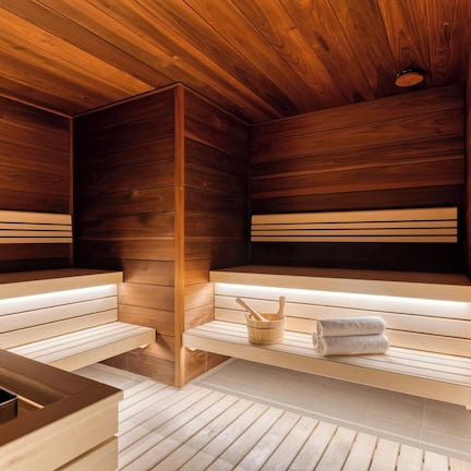 A sauna with wooden benches and a stone basin.