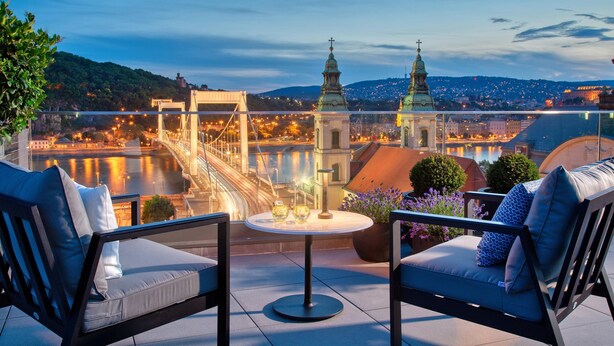 A terrace with two chairs and a table, overlooking a river and cityscape with historic buildings and a bridge. - Matild Palace, a Luxury Collection Hotel, Budapest (Budapest)