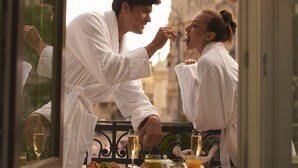 A couple dining at a table with a view of a building through a window. - Matild Palace, a Luxury Collection Hotel, Budapest (Budapest)
