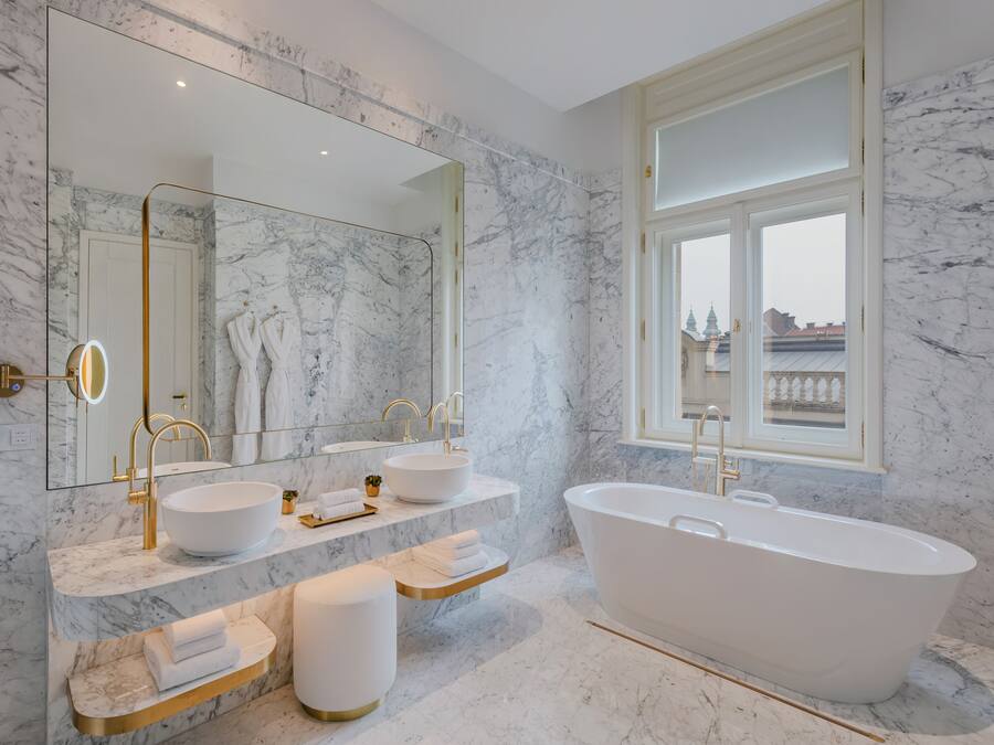 A modern bathroom with a freestanding bathtub, two sinks, and a large mirror.