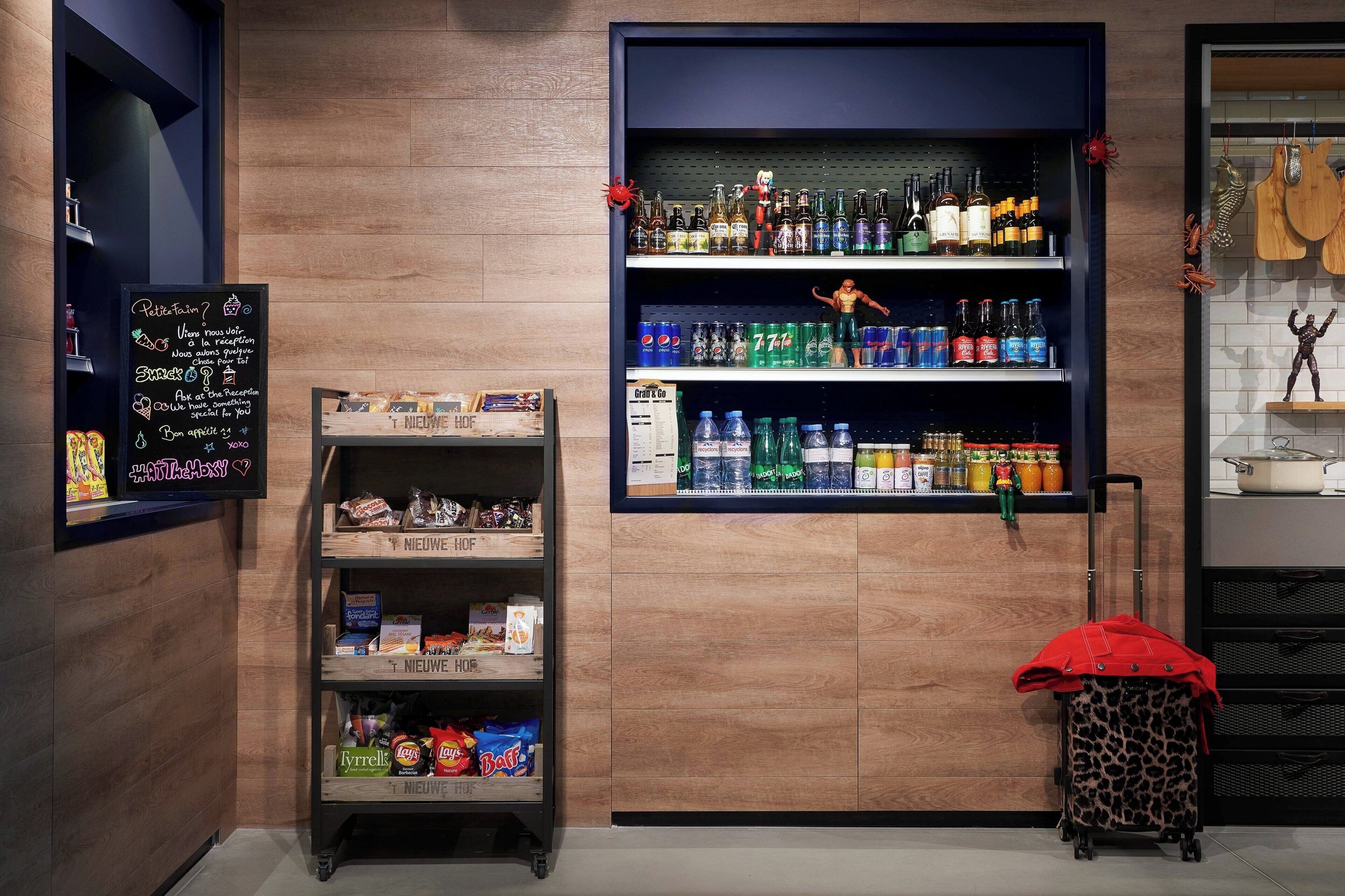 A bar area with shelves of beverages, snacks, and a chalkboard with messages.
