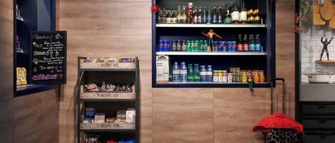 A bar area with shelves of beverages, snacks, and a chalkboard with messages.