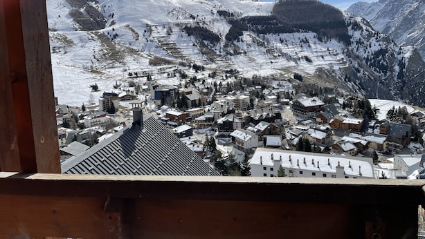 Eine Bergstadt mit schneebedeckten Gebäuden und einem klaren Himmel.