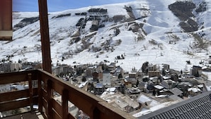 Ein mit Schnee bedeckter Berg mit einem Skigebiet und Gebäuden am Fuße.
