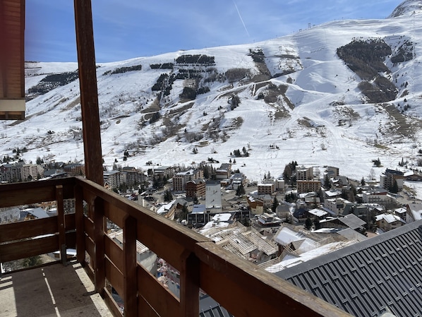 A snow-covered mountain with a ski resort and buildings at the base.