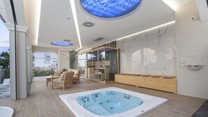 A modern spa area with a hot tub, seating, and a glass-enclosed shower area. - Sorrento Dream Villa (Sorrento)