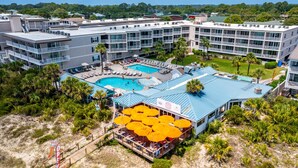 A hotel with a pool, multiple balconies, and outdoor seating areas. - Family-friendly Tybee Island condo w/ pools, ocean views & walk to beach (Tybee Island)
