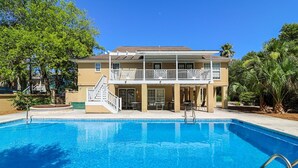 Ein zweistöckiges Gebäude mit Pool davor.