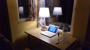 A small desk with a laptop, two lamps, a bottle of water, and a keychain. - Immaculate 1-bed House in Nagymaros (Nagymaros)