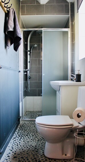 A bathroom with a shower, toilet, and sink. - Charming vacation home with a terrace and garden (Sart-en-Fagne)
